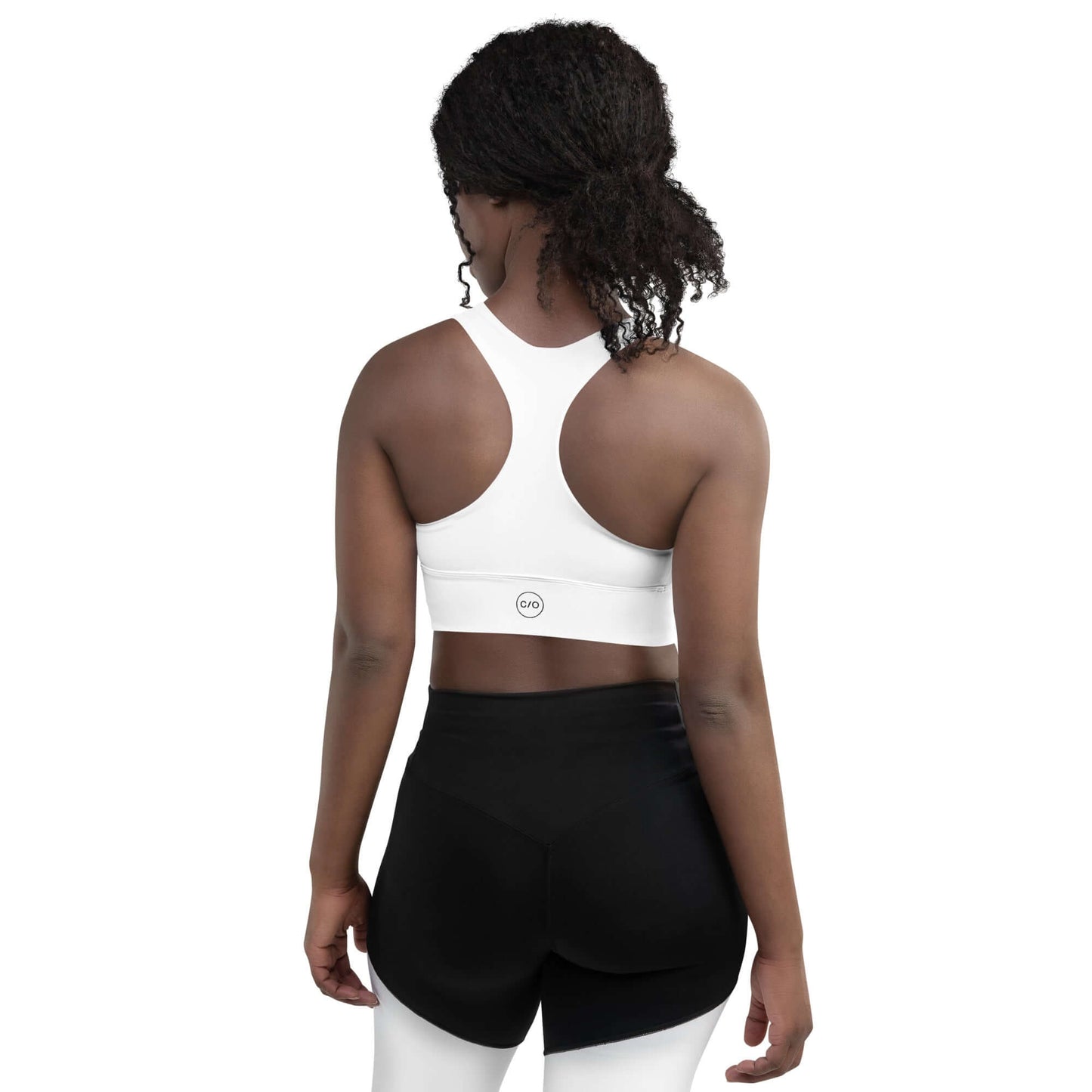Woman wears Neue Supply Co. Longline Sports Bra in White. Back view of model on white background.
