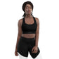Woman wears Neue Supply Co. Longline Sports Bra in Black. Front view of model looking into camera with white background.