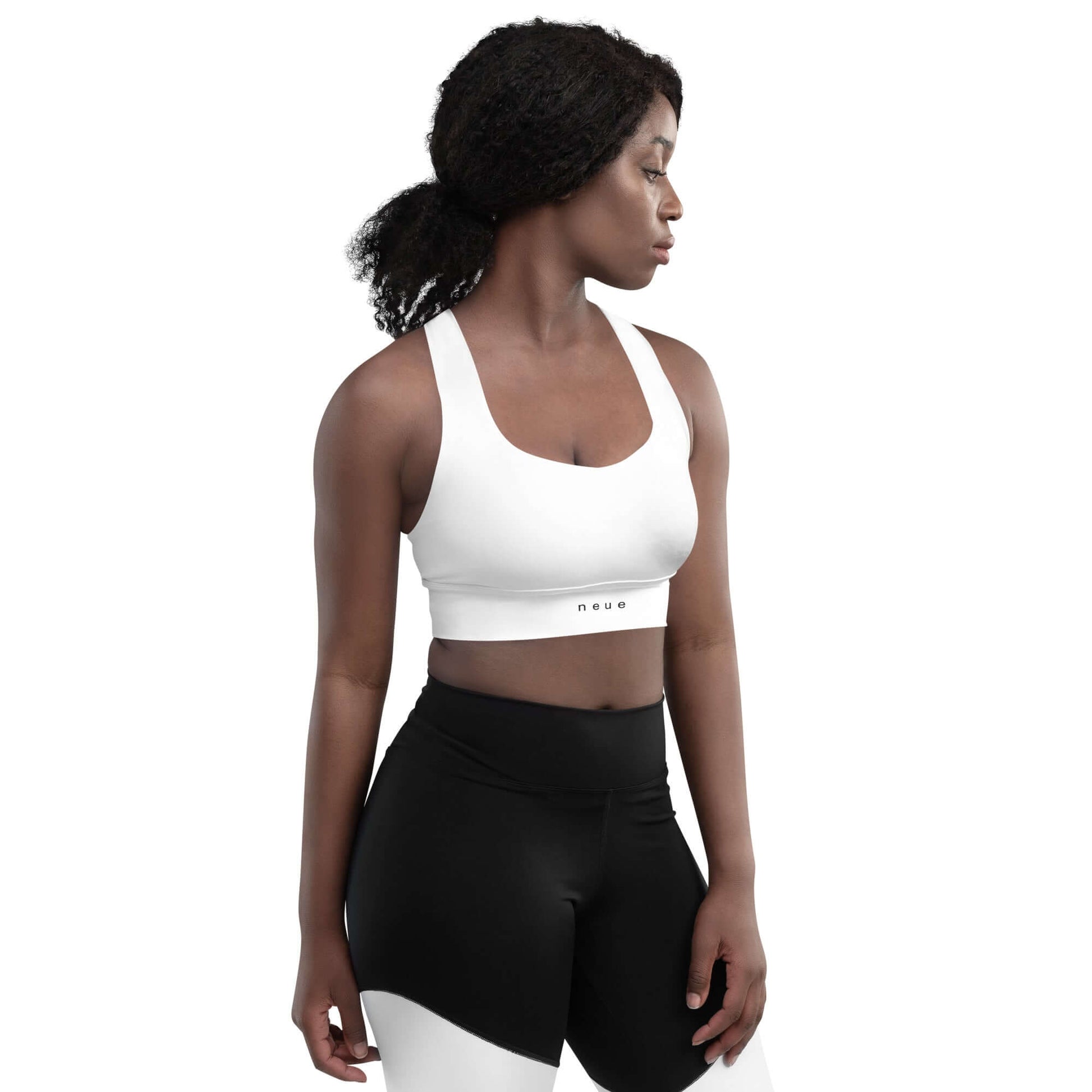 Woman wears Neue Supply Co. Longline Sports Bra in White. Front view of model with white background.