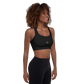 Woman wears Neue Supply Co. Essential Padded Sports Bra in Black. 3/4 view of model smiling.
