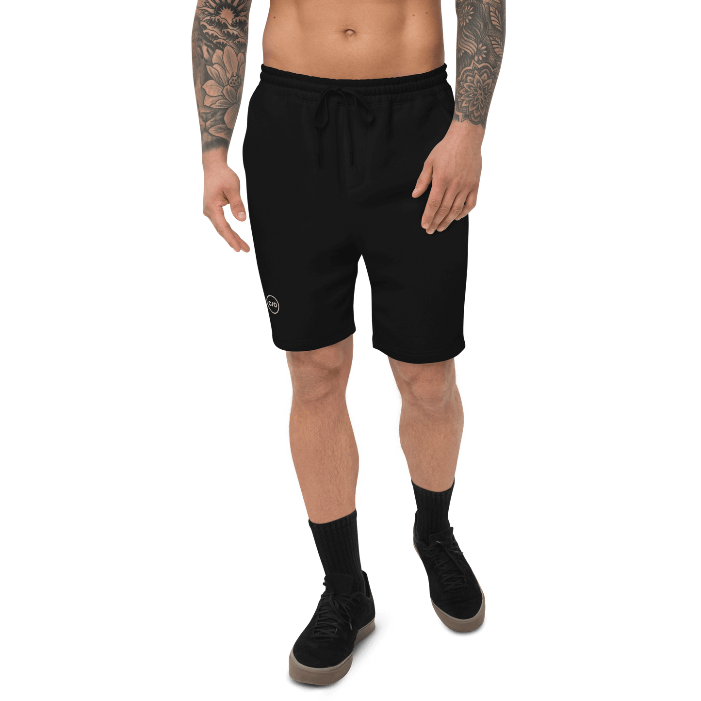 Man wearing Neue Supply Co. Men's Essential Fleece Sweat Shorts in Black. Front view of model on white background with black socks and shoes.